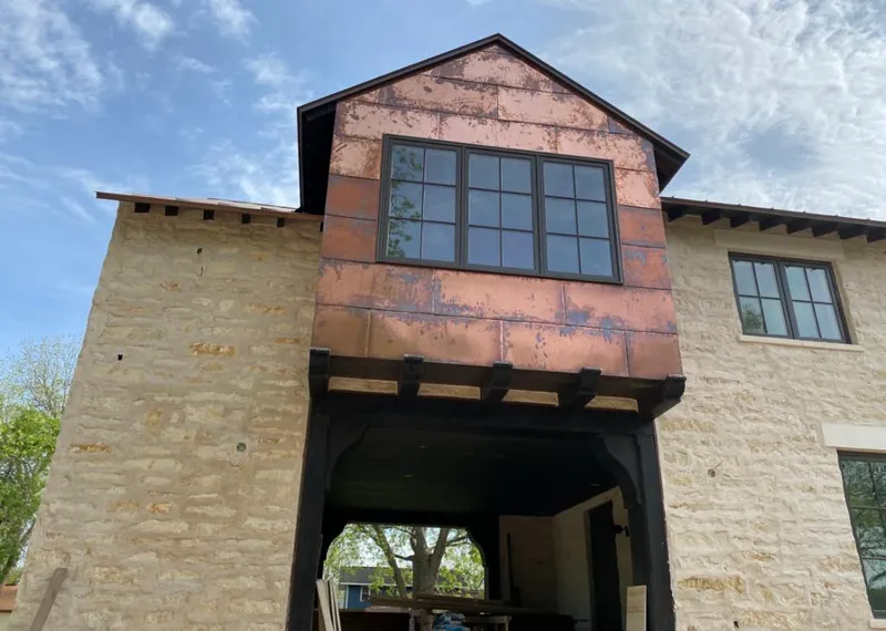 Copper metal panel facade on a stone building for Metal Roof Coating in Taylor