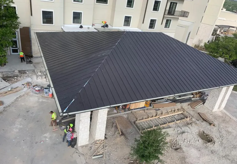 Metal roofing installation team working on a commercial building in Taylor